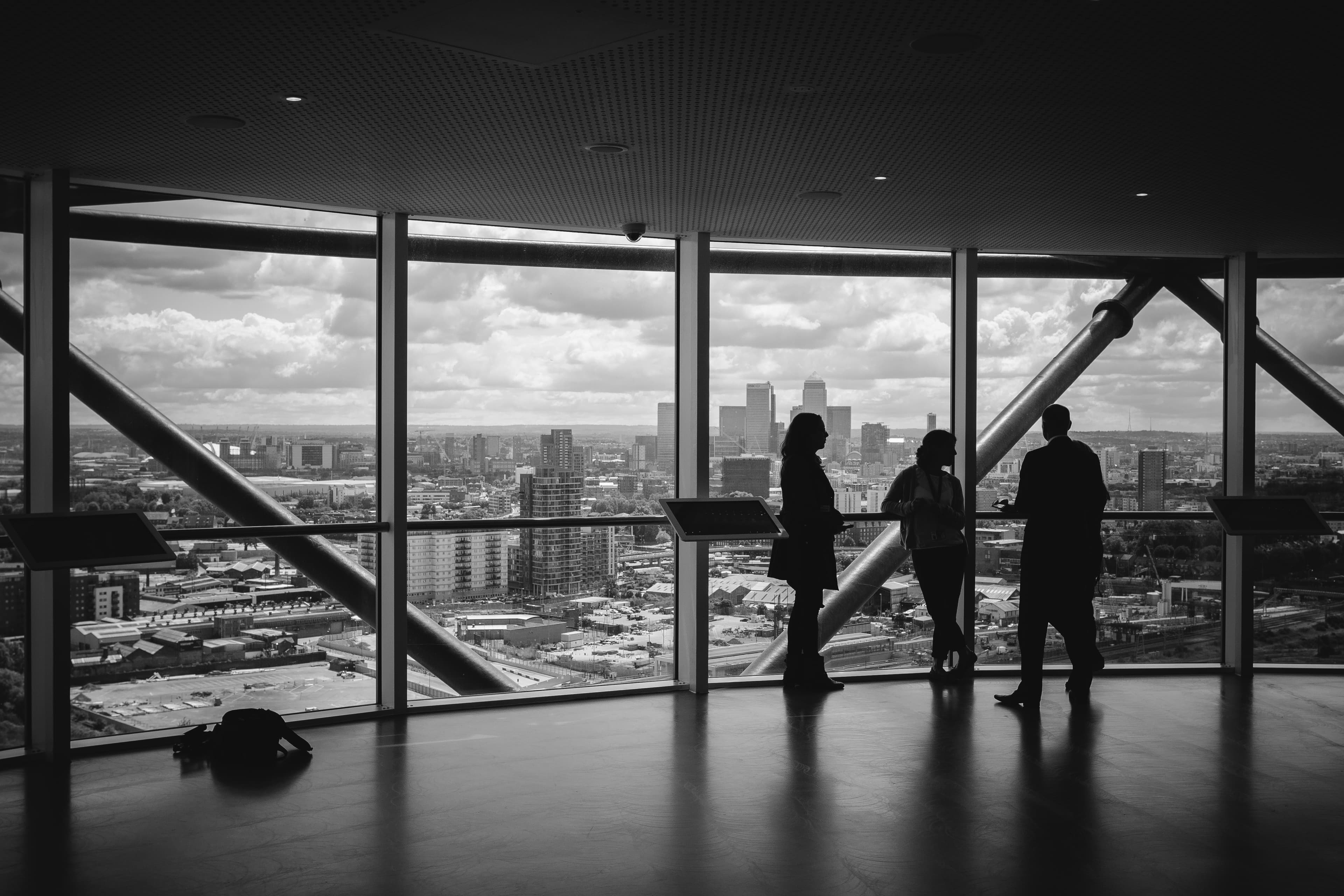Silhuetas em ambiente corporativo diante da cidade, representando decisões empresariais e sucessão societária.